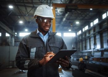 Man with a safety helmet using a tablet.